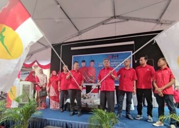 AHMAD Said (empat, kanan) dan Ahmad Razif Abdul Rahman (lima, kiri) mengibarkan bendera UMNO pada majlis Pelancaran Jentera PRN UMNO Kuala Nerus di Seberang Takir, Kuala Nerus, semalam.