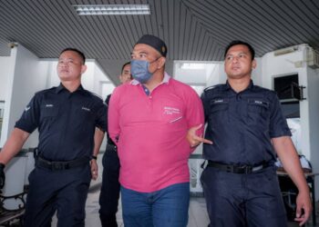 TERTUDUH diiring keluar anggota polis selepas mengaku tidak bersalah di Mahkamah Sesyen, Ayer Keroh, Melaka atas pertuduhan menyebabkan cedera parah terhadap isterinya dan ugutan bunuh. - UTUSAN/SYAFEEQ AHMAD