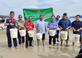 CHAN Foong Hin (tiga dari kanan) dan Adnan (dua dari kanan) bergambar sebelum melepaskan benih ketam renjung sempena Program Sambutan Hari Laut Sedunia 2023 di Pantai Tanjung Biru, Port Dickson, hari ini. UTUSAN/NOR AINNA HAMZAH.