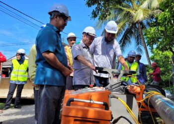 AZAMI Mohd. Nor (dua dari kiri) diberikan penerangan mengenai kelengkapan digunakan untuk kerja penggantian paip AKSB di Pasir Tumbuh, Kota Bharu, Kelantan hari ini. UTUSAN/MUSTAQIM MOHAMED