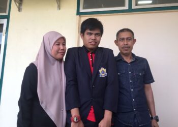 MUHAMMAD Aziq Asri (tengah) memperoleh 8A 1B dalam keputusan Sijil Pelajaran Malaysia (SPM) 2022, ditemani ibu bapanya mengambil slip keputusan di Sekolah Menengah Kebangsaan Bukit Rangin, Kuantan, di sini, hari ini.