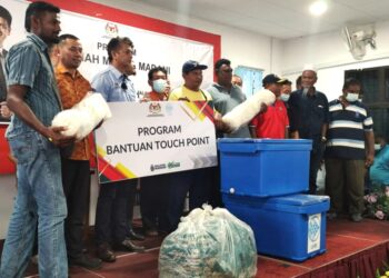 MUHAMMAD Faiz Fadzil (tiga dari kiri) menyampaikan Bantuan Touch Point kepada nelayan berupa jaring dan kotak ikan berinsulasi pada Majlis Ramah Mesra Madani Bersama Pengerusi LKIM di Dewan Serbaguna PNK Telok Kemang di Kampung Teluk, Pasir Panjang di Port Dickson hari ini.