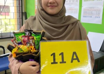 NURUL IZZAH Khadri menunjukkan placard 11A keputusan peperiksaan Sijil Pelajaran Malaysia 2022 di Sekolah Menengah Agama Tengku Ampuan Hajah Afzan Pahang di Jerantut, Pahang hari ini.