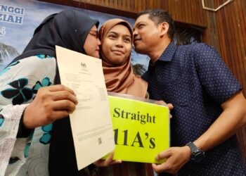 INSYIRAH Noor Ain menerima kucupan daripada kedua ibu bapanya pada Pengumuman Keputusan SPM 2022 di SMKA Sharifah Rodziah di Telok Mas, Melaka. - UTUSAN/MUHAMMAD SHAHIZAM TAZALI