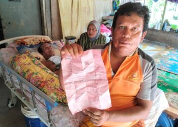 MOHD. Nazri Md.Nor menunjukkan bil elektrik tertunggak ketika ditemui di Kampung Tok Rusa Pasir Mas, Kelantan-UTUSAN.ROHANA ISMAIL