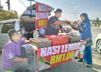 MUHAMMAD Lukman Hakim (kiri) melayan pelanggan yang singgah ke gerainya untuk membeli nasi lemak di Pasir Pekan Tumpat, Kelantan. - UTUSAN/ROHANA ISMAIL