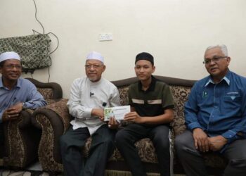AHMAD Yakob (dua kiri) menyampaikan sumbangan kepada Muhammad Syahril selepas  melawat pelajar berkenaan di rumah sewanya di Kampung Kandis, Bachok, Kelantan hari ini-IHSAN AHMAD YAKOB