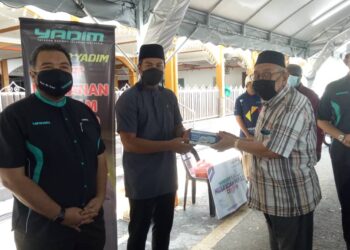 TUAN KAMARUL ARIEF Soh (kiri) dan Ahli Lembaga Pemegang Amanah Yadim, Muhammad Zikri Zulkifli (dua dari kiri) menyampaikan bantuan dalam  Program Dapur Yadim di Masjid Hashim Yahya, Jalan Perak, Georgetown, Pulau Pinang.