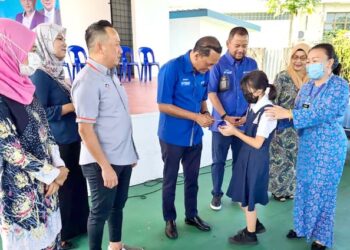 JEFFEREY Nor Mohamed menyerahkan bantuan persekolah kepada murid di kawasan Parlimen Putatan di Sabah.