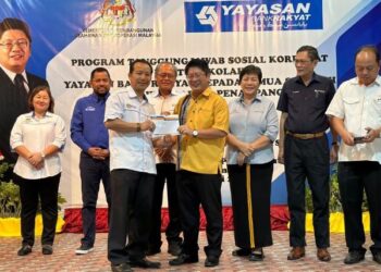 EWON Benedick menyerahkan bantuan persekolahan yang diperuntukkan YBR kepada wakil sekolah dalam satu majlis di Dewan SM St. Michael, Penampang, Sabah. - IHSAN YBR
