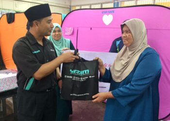 NASRUL Hadi Saidi (kanan) menyampaikan sumbangan kepada mangsa banjir di PPS SK Bukit Nanas, Kuala Nerus, Terengganu, hari ini. - UTUSAN/TENGKU DANISH BAHRI TENGKU YUSOFF