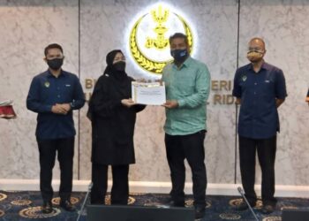 KHAIRUL Shahril Mohamed (tiga dari kanan) menyerahkan watikah pelantikan pengurus-pengurus pasukan Sukma Perak di Ipoh hari ini. - UTUSAN