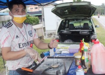ZAFREE Zahar terpaksa menjual burger secara ‘bidan terjun’ disebabkan pasar malam masih belum dibenarkan beroperasi ketika ditemui di Taman Megah, Pontian, Johor.