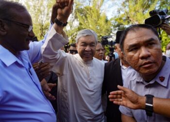 AHMAD ZAHID HAMIDI mengangkat tangan tanda syukur dan gembira selepas dilepas dan dibebaskan di atas 40 pertuduhan di Mahkamah Tinggi Shah Alam, semalam.