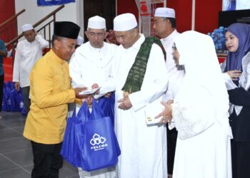 AHMAD Zahid Hamidi (tengah) menyampaikan sumbangan pada Program Ihya Ramadan al-Mubarak Tadarus al-Quran Perdana Bagan Datuk di Kompleks UMNO Bagan Datuk hari ini. - UTUSAN/MUHAMAD NAZREEN SYAH MUSTHAFA