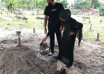 ZIZAN Razak bersama ibunya, Anai Ibrahim menyiram air ke pusara Allahyarham Zainoon Abdullah dikebumikan di Tanah Perkuburan Kampung Gong Pasir, Dungun, Terengganu kira-kira pukul 5.30 petang tadi.