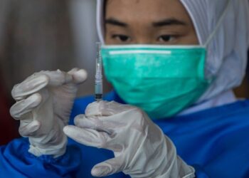 PETUGAS perubatan menyediakan jarum suntikan vaksin Sinovac untuk diberikan kepada kanak-kanak sekolah berusia 12 hingga 18 tahun di Surabaya, Indonesia. - AFP