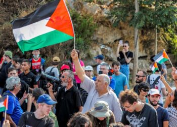 SEKUMPULAN penunjuk perasaan mengibarkan bendera Palestin ketika demonstrasi membantah penempatan Yahudi di Sheikh Jarrah di Baitulmuqaddis. - AFP