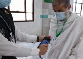 PETUGAS Arab Saudi mengimbas kad jemaah bagi mengelakkan sebarang sentuhan di tanah suci. - AFP