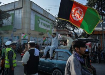 DUA penduduk mengibarkan bendera Afghanistan sempena Hari Kebangsaan Ke-102 negara itu di Kabul. - AFP