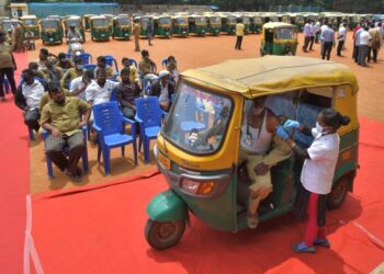 PEMANDU kenderaan roda tiga menerima suntikan vaksin Covid-19 di Bangalore, India. - AFP