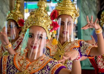 SEKUMPULAN penari tradisional memakai alat perlindungan muka sebagai langkah pencegahan Covid-19 ketika membuat persembahan di Bangkok, Thailand. - AFP