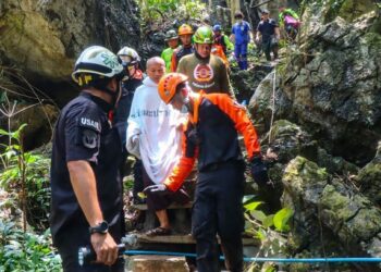 MANAS Kemgoh (berkain putih) diselamatkan selepas terperangkap selama dua hari di dalam gua yang dinaiki air di utara Thailand. - AFP