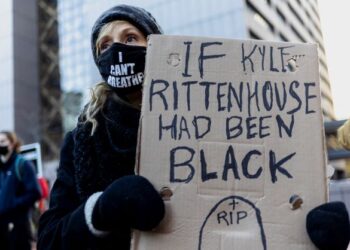 SEORANG peserta demonstrasi memegang plakad tidak menyokong Kyle Rittenhouse dalam satu protes di Minneapolis, Amerika Syarikat. - AFP