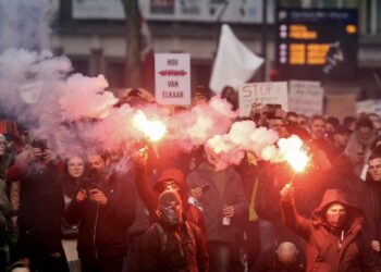 PENUNJUK perasaan membakar suar semasa protes bantah sekatan Covid-19 di Brussels, Belgium.- AFP