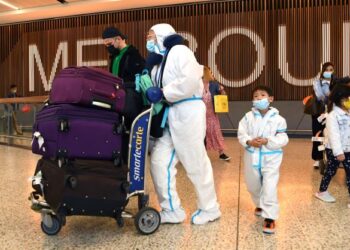 PENGEMBARA antarabangsa dengan pakaian perlindungan diri (PPE) tiba di Lapangan Terbang Tullamarine, Melbourne, Australia. - AFP