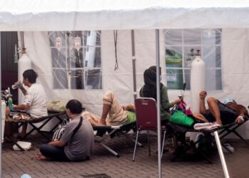 BEBERAPA pesakit Covid-19 menerima rawatan di hospital lapangan di Yogyakarta, Indonesia pada Julai 2021. - AFP