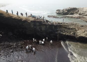 SEJUMLAH petugas membersihkan kawasan tepi pantai yang dicemari tumpahan minyak di pekan Ancon, utara Lima di Peru. - AFP