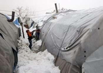 SEORANG kanak-kanak lelaki membersihkan salji di atas bumbung khemah di kem pelarian berhampiran bandar Jisr al-Shughur, Idlib, Syria. - AFP