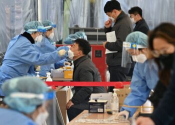 PENDUDUK melakukan ujian calitan hidung di sebuah pusat saringan Covid-19 di Seoul. - AFP