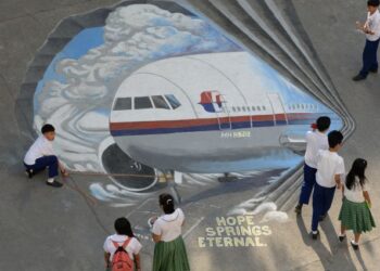 PELAJAR sekolah di Manila mengelilingi lukisan mural gergasi MH370 sebagai tanda solidariti terhadap kru kabin dan penumpang yang hilang. - AFP
