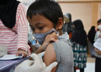 SEORANG kanak-kanak menerima suntikan vaksin Covid-19 di sekolah di Jakarta, Indonesia. - AFP