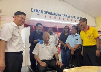 CHOW Kon Yeow (kiri) memerhatikan P. Ramasamy (tengah) yang mencuba rawatan kiropraktik di Taman Chai Leng, Perai, Pulau Pinang hari ini. - Pix: SITI NUR MAS ERAH AMRAN