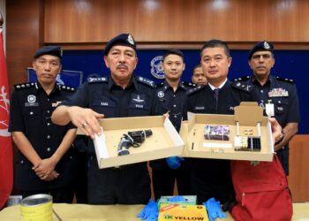 MUHAMAD Zaki (depan kiri) menunjukkan pistol yang dirampas semasa sidang akhbar di Ibu Pejabat Polis Kontinjen Kelantan, Kota Bharu, Kelantan hari ini.- UTUSAN/KAMARUL BISMI KAMARUZAMAN