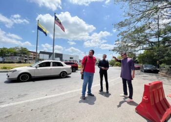 IZIZAM Ibrahim (kanan) turun padang bagi meninjau laluan di sekitar Bulatan Padang Besar, Perlis yang sering kali sesak dengan kenderaan pengunjung sewaktu cuti persekolahan dan hujung minggu. -UTUSAN/ASYRAF MUHAMMAD