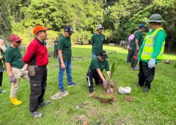 MOHD. Shukri Ramli (tiga dari kiri) menyaksikan Hasnol Zam Zam Ahmad (empat dari kiri) membuat gimik menanam anak pokok kelapa sewaktu program RAKERSAP di pekarangan kawasan tangki air SAP Anak Chelong, Kangar, Perlis hari ini. -UTUSAN/ASYRAF MUHAMMAD