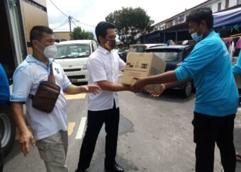 AZMIZAM (dua dari kanan) mengangkat kotak berisi bantuan makanan di pusat pengagihan bakul makanan di Taman Telok Gedung Indah, Klang, Selangor hari ini. - Utusan/MOHAMAD NAUFAL MOHAMAD IDRIS