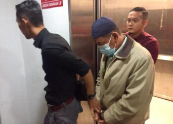 CHE Sa'adon Che Yahya (tengah) yang dijatuhi hukuman penjara lima tahun atas kesalahan salah guna kuasa dibawa keluar daripada Mahkamah Sesyen Kuala Terengganu, hari ini. - UTUSAN/TENGKU DANISH BAHRI TENGKU YUSOFF