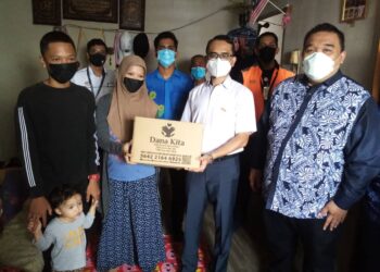 MOHD. Shahrizal Mohd. Salleh (barisan hadapan, dua dari kanan) diapit Nazir (barisan hadapan, kanan) memberikan bantuan kepada salah seorang keluarga OKT di Flat Sri Perantau, Klang, Selangor hari ini. - UTUSAN / MOHAMAD NAUFAL MOHAMAD IDRIS