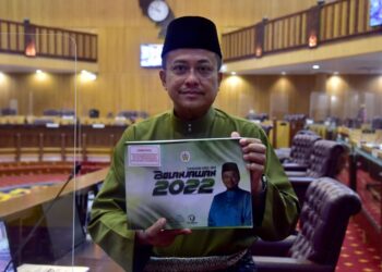 AHMAD Samsuri Mokhtar memegang buku Belanjawan Terengganu 2022 yang bertemakan ‘Merakyatkan Sejahtera Untuk Semua’ dalam sidang Dewan Undangan Negeri (DUN) Terengganu Ke-14 di Wisma Darul Iman, di Kuala Terengganu hari ini. - UTUSAN/PUQTRA HAIRRY ROSLI