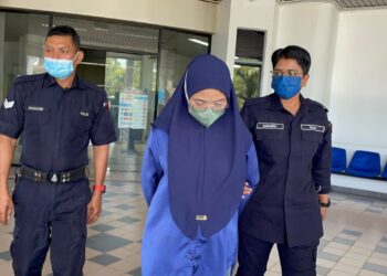 MASANIZAH Roslan diiring keluar anggota polis selepas dihadapkan ke Mahkamah Sesyen, Ayer Keroh, Melaka atas pertuduhan mengabaikan tiga anak kandungnya tanpa jagaan.