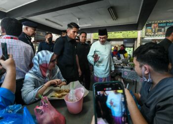 Anwar Ibrahim (kanan) beramah mesra bersama orang ramai ketika meluangkan masa makan tengah hari di Kedai Ikan Bakar Tangling di Kuala Lumpur, hari ini. - UTUSAN/ARIZ RUSADIO 