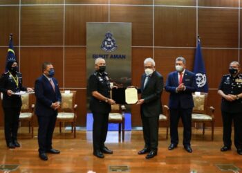 HAMZAH Zainuddin menyerahkan watikah pelantikan Ketua Polis Negara kepada Acryl Sani Abdullah Sani yang dilantik secara kontrak selama dua tahun di Ibu Pejabat Polis Bukit Aman, Kuala Lumpur, hari ini. - FOTO/AFIQ RAZALI