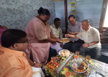 SAARANI Mohamad (kanan) menjamah juadah pada Program Ramah Mesra dengan keluarga K. Devagi sempena Hari Deepavali di Kampung Chengai, Sungkai, dekat Tanjung Malim hari ini. - UTUSAN/AIN SAFRE BIDIN