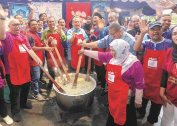 Dr.ABDUL Fattah Abdullah (lima kiri), Datuk Dr Yacob Mustafa (empat kiri), Roshidi Zabidi (tiga kiri) dan selebriti, Datuk Fizz Fairuz (enam kanan) gotong-royong mengacau bubur lambuk pada program CSR bubur lambuk Adabi di Jabatan Akauntan Negara di Putrajaya semalam. – utusan/FAISOL MUSTAFA.