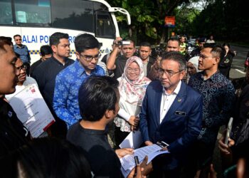Adly Zahari (kanan) menerima memorandum daripada Parti Ikatan Demokratik Malaysia (MUDA) berkenaan siasatan skandal kapal LCS di hadapan Parlimen Malaysia semalam.